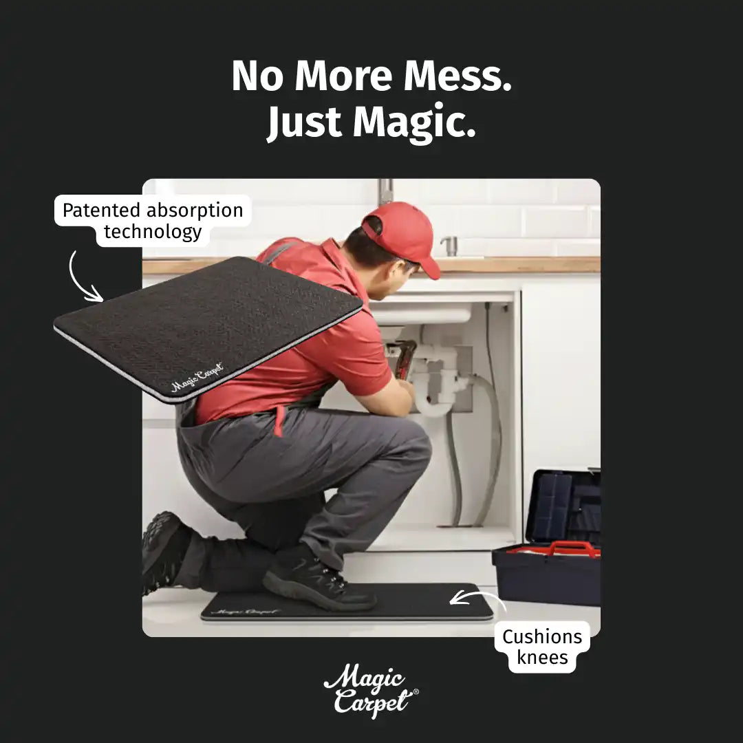 Plumber kneeling on a black Magic Carpet mat while working under a sink