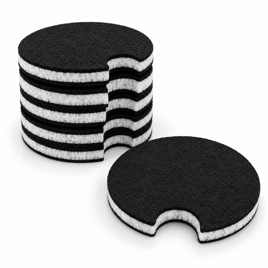 Six black Magic Carpet car coasters with pale fibrous cores and removal notches on a white background